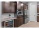 Modern kitchen with dark wood cabinets, stainless steel appliances, and a built-in wine cooler at 21622 E Via De Arboles --, Queen Creek, AZ 85142