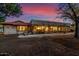 Back exterior view of house with lighted patio at 22206 N La Senda Dr, Scottsdale, AZ 85255