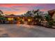 Evening view of a Spanish-style home with palm trees and a gated entryway at 22206 N La Senda Dr, Scottsdale, AZ 85255