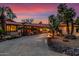 Beautiful desert home exterior at sunset, showcasing a large driveway and landscaping at 22206 N La Senda Dr, Scottsdale, AZ 85255