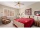 Cozy bedroom featuring a bed, leather chair, side table and window with plantation shutters at 22801 N Las Vegas Dr, Sun City West, AZ 85375