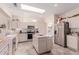 Well-lit kitchen featuring a skylight, central island, stainless steel appliances, and ample cabinet space at 22801 N Las Vegas Dr, Sun City West, AZ 85375