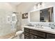 Modern bathroom featuring a glass shower, neutral stone counters, and dark wood cabinets at 2625 N 24Th St # 36, Mesa, AZ 85213