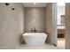 Bathroom featuring a freestanding soaking tub and tiled shower at 28110 N 96Th Pl, Scottsdale, AZ 85262