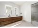 Modern bathroom with double vanity, large mirror, and walk-in shower at 28110 N 96Th Pl, Scottsdale, AZ 85262