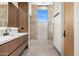 Elegant bathroom with a modern vanity, stone wall accent, and access to a bright shower room, seamlessly blending luxury at 28110 N 96Th Pl, Scottsdale, AZ 85262