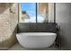 Luxurious bathroom features a standalone tub beneath a window with mountain views, combining relaxation and elegance at 28110 N 96Th Pl, Scottsdale, AZ 85262