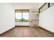 Bright bedroom with wood floors, large window, and stone accent wall at 28110 N 96Th Pl, Scottsdale, AZ 85262