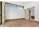 Bright bedroom with wood floors, a large window, and a sliding barn door to the bathroom at 28110 N 96Th Pl, Scottsdale, AZ 85262