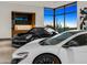 Luxury cars parked inside garage with bar and desert scenery at 28110 N 96Th Pl, Scottsdale, AZ 85262