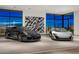 Elegant garage featuring a black Porsche and a silver McLaren, complemented by modern art and expansive windows at 28110 N 96Th Pl, Scottsdale, AZ 85262