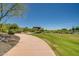 Paved pathway winds through a grassy area with desert landscaping at 28731 N 20Th Ln, Phoenix, AZ 85085