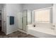 Bright bathroom showcasing a glass shower, soaking tub, and a window for natural light at 29050 N Mountain View Rd, San Tan Valley, AZ 85143