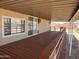 Large, covered back patio with a wooden deck and beige stucco exterior at 29967 N Sandridge Dr, Queen Creek, AZ 85144