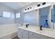 Well-lit bathroom with double sinks and tub, offering modern fixtures and design at 3591 S Larkspur Way, Chandler, AZ 85248