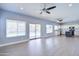 Open concept living room with gray walls, ceiling fans, and glass sliding door to the pool at 3591 S Larkspur Way, Chandler, AZ 85248