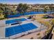 Aerial view of well-maintained tennis courts near a serene lake and lush landscaping in a desirable community at 3591 S Larkspur Way, Chandler, AZ 85248