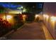 Night view of a backyard featuring a paved patio, block fence, garden lights, fountain and colorful foliage at 5373 W Dublin Ct, Chandler, AZ 85226