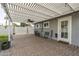 Covered patio featuring brick pavers, ceiling fan, and access to the home's interior and backyard at 7018 E Wilshire Dr, Scottsdale, AZ 85257