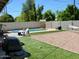 Backyard with a pool, artificial grass, a grill, and a hammock in a desert landscape at 7018 E Wilshire Dr, Scottsdale, AZ 85257