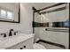 Modern bathroom featuring black and white tile, glass shower doors and a marble top vanity at 7018 E Wilshire Dr, Scottsdale, AZ 85257