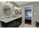 Bathroom features a double sink vanity, modern mirrors, and an arched doorway to the bedroom at 7018 E Wilshire Dr, Scottsdale, AZ 85257