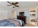 Well-lit bedroom with ceiling fan, TV, dresser and an adjacent bathroom with shower at 7018 E Wilshire Dr, Scottsdale, AZ 85257