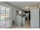 A bright laundry room with white cabinets, appliances, tile floor, and access to the outdoor patio at 7018 E Wilshire Dr, Scottsdale, AZ 85257