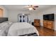 Comfortable bedroom with hardwood floors, a ceiling fan, and sliding barn doors to the closet at 7018 E Wilshire Dr, Scottsdale, AZ 85257