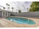 An inviting backyard pool with a concrete surround, set against a backdrop of palm trees at 7018 E Wilshire Dr, Scottsdale, AZ 85257