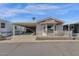 Tan colored manufactured home with carport and small fenced patio at 8700 E University Dr # 2216, Mesa, AZ 85207