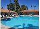 Community swimming pool with multiple lounge chairs at 8700 E University Dr # 2216, Mesa, AZ 85207