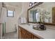 Bathroom featuring a sink, wood cabinets, and large mirror with floral accents at 9290 E Thompson Peak Pkwy # 444, Scottsdale, AZ 85255