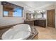 Bright bathroom featuring a soaking tub, double vanity, and a large window overlooking a bright, sunny day at 9290 E Thompson Peak Pkwy # 444, Scottsdale, AZ 85255