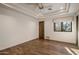 Minimalist bedroom with hardwood floors, tray ceiling, and a window framing views of desert foliage at 9290 E Thompson Peak Pkwy # 444, Scottsdale, AZ 85255