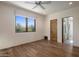 Bright, airy bedroom with hardwood floors, a large window offering natural light, and an ensuite bathroom at 9290 E Thompson Peak Pkwy # 444, Scottsdale, AZ 85255