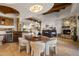 Open-concept dining area featuring a stone fireplace, wood beams, and a round wooden table with plush chairs at 9290 E Thompson Peak Pkwy # 444, Scottsdale, AZ 85255