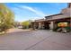 Exterior home view with a circular driveway and beautiful desert landscaping at 9290 E Thompson Peak Pkwy # 444, Scottsdale, AZ 85255