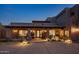 Elegant home exterior with a tiled roof and front courtyard with water feature, lit at dusk at 9290 E Thompson Peak Pkwy # 444, Scottsdale, AZ 85255