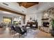 Inviting living room featuring stone fireplace, wood beam ceiling, stylish seating, stone flooring and a desert view window at 9290 E Thompson Peak Pkwy # 444, Scottsdale, AZ 85255