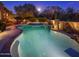 Swimming pool with hot tub lit up at night, surrounded by mature landscaping for privacy at 9290 E Thompson Peak Pkwy # 444, Scottsdale, AZ 85255