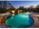 Serene swimming pool with spa and stone-lined diving board, beautifully illuminated at twilight at 9290 E Thompson Peak Pkwy # 444, Scottsdale, AZ 85255