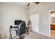 Home office with glass desk and sliding door to the bathroom at 9477 W Frank Ave, Peoria, AZ 85382