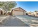 Tan colored house with a two-car garage and gravel driveway at 9477 W Frank Ave, Peoria, AZ 85382