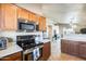 Modern kitchen with stainless steel appliances and wood cabinets at 9477 W Frank Ave, Peoria, AZ 85382