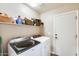 Laundry room with Whirlpool washer and dryer and overhead shelving at 9477 W Frank Ave, Peoria, AZ 85382