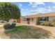 House exterior with brick facade, green lawn, and mature tree in front at 9890 N Balboa Dr, Sun City, AZ 85351