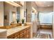 Primary bathroom with double vanity, soaking tub, and glass block window at 11077 E Cinder Cone Trl, Scottsdale, AZ 85262