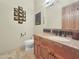 Neutral half bathroom with a wooden vanity with stone counters and a toilet at 11429 S Wilson Ln, Goodyear, AZ 85338