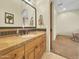 Neutral bathroom with a wooden vanity with stone counters at 11429 S Wilson Ln, Goodyear, AZ 85338